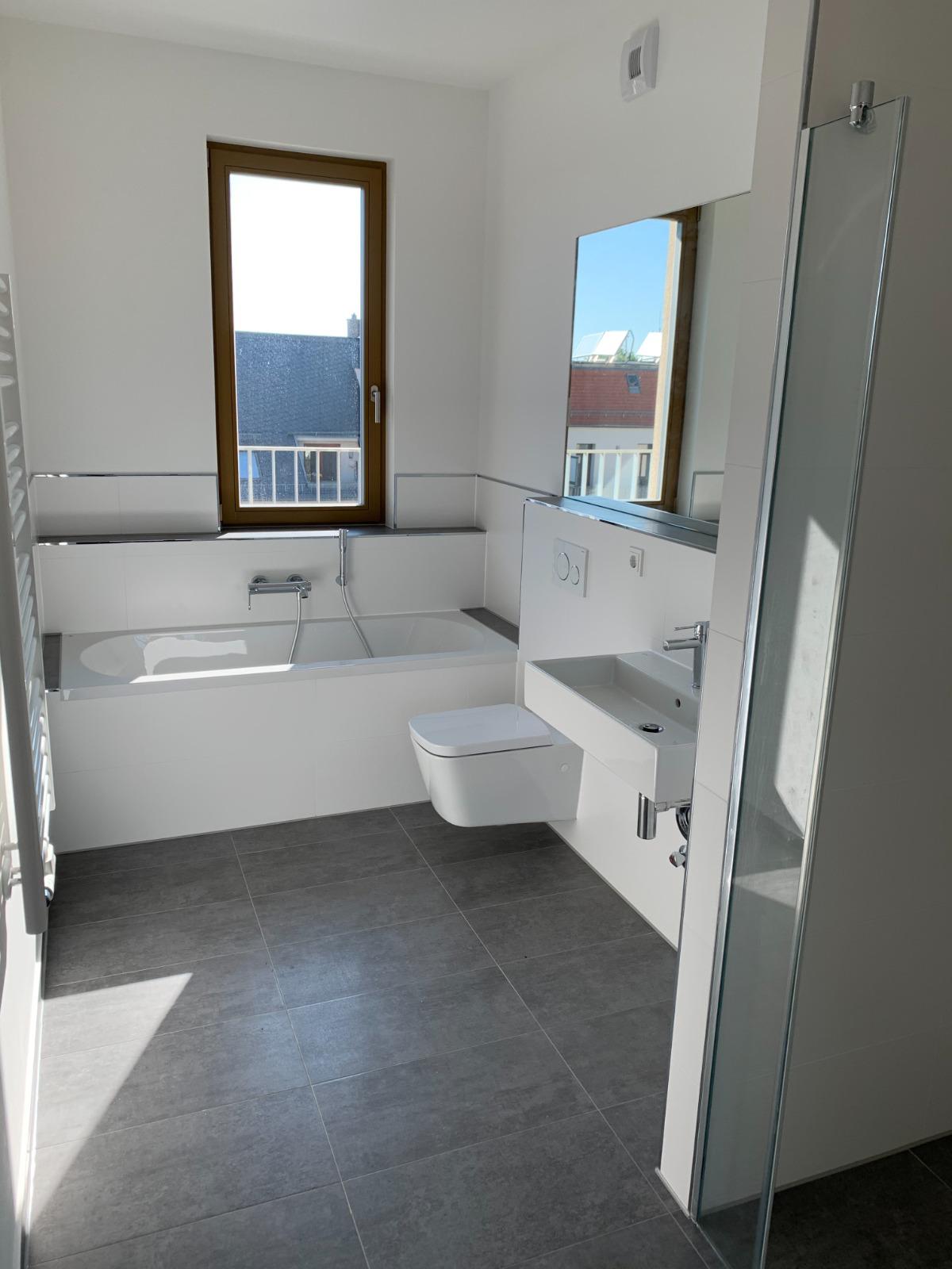 Modernes Bad mit Badewanne, Dusche und Fenster