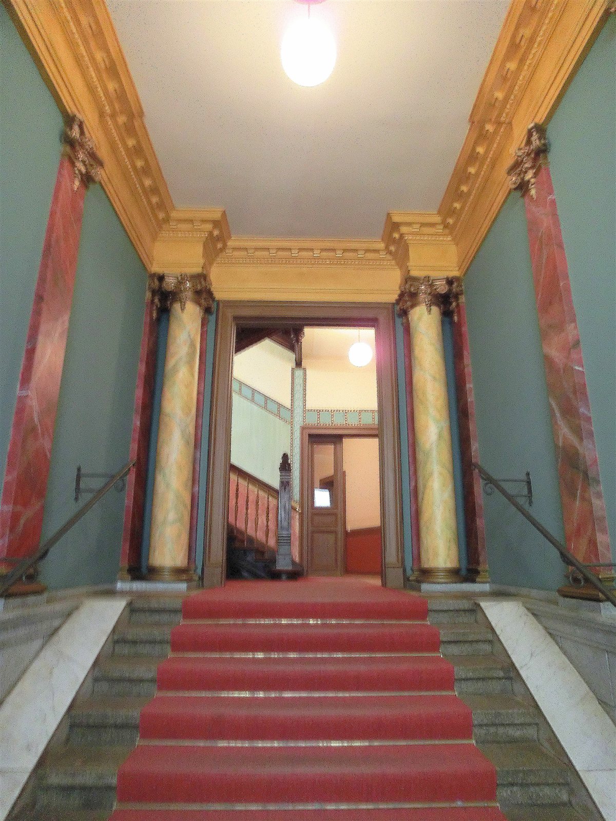 Prachtvestibül mit Säulen und rotem Läufer