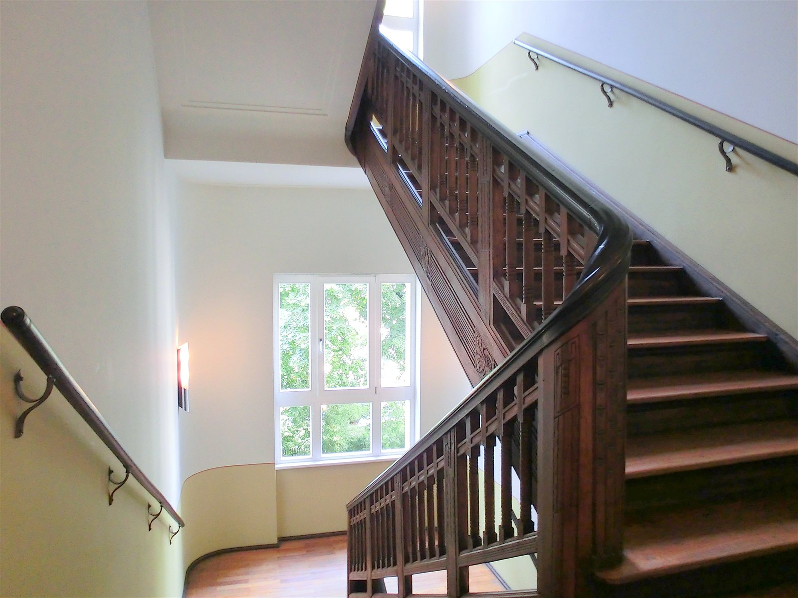 Helles Treppenhaus mit Holztreppe
