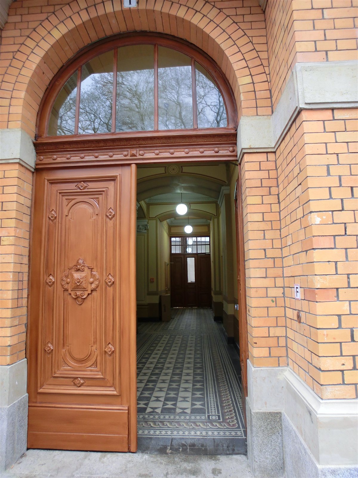 Klinkerportal mit geschnitzter Holztür