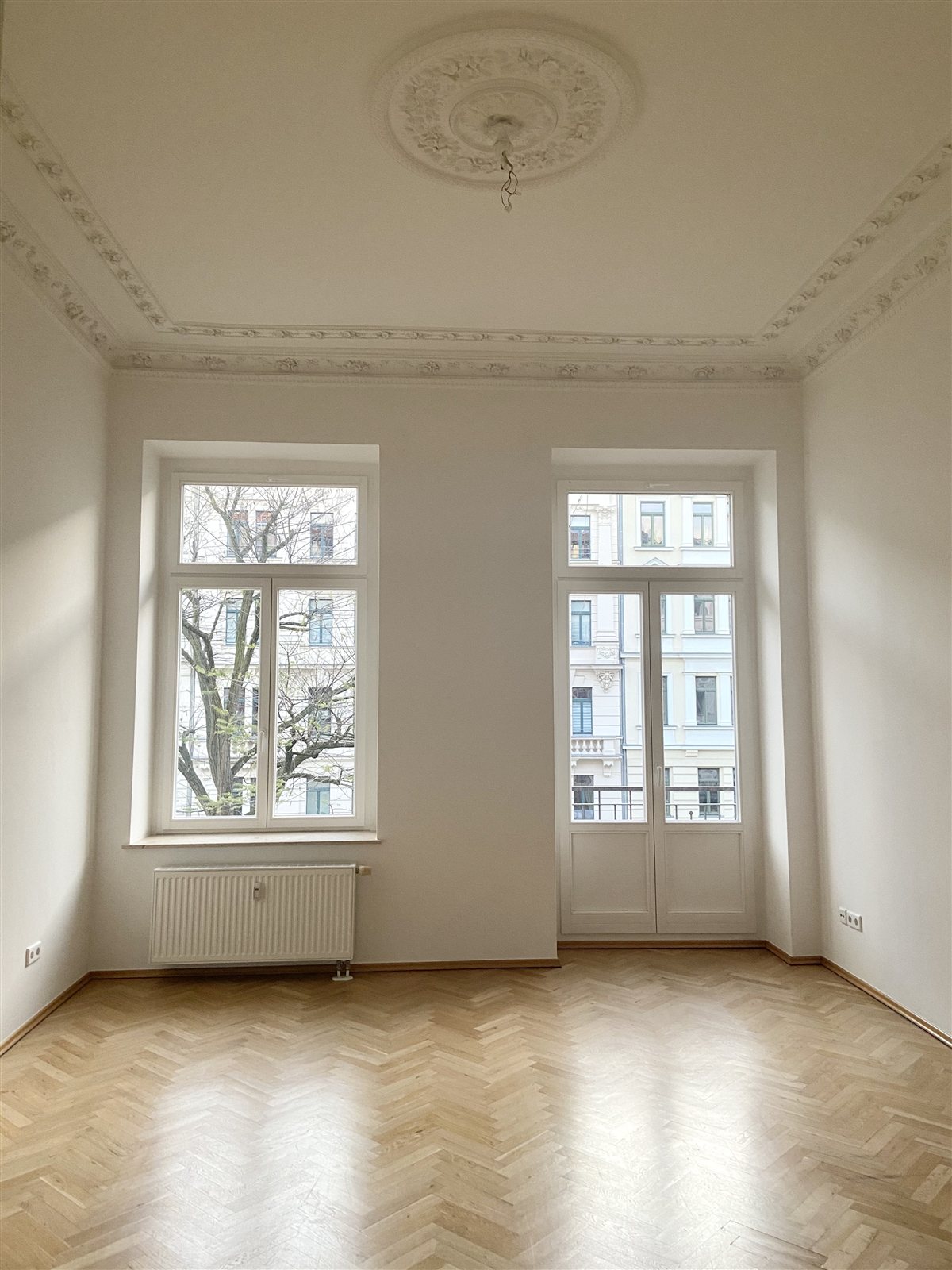 Zimmer mit Stuckdecke, Balkontür und Fischgrätparkett